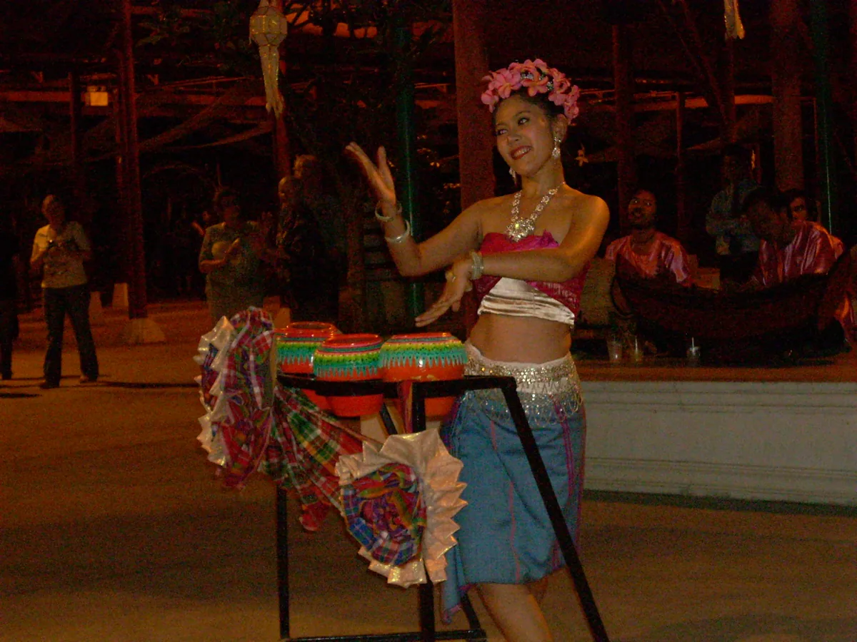 A Siam Niramit performer in an ornate gold headdress and costume